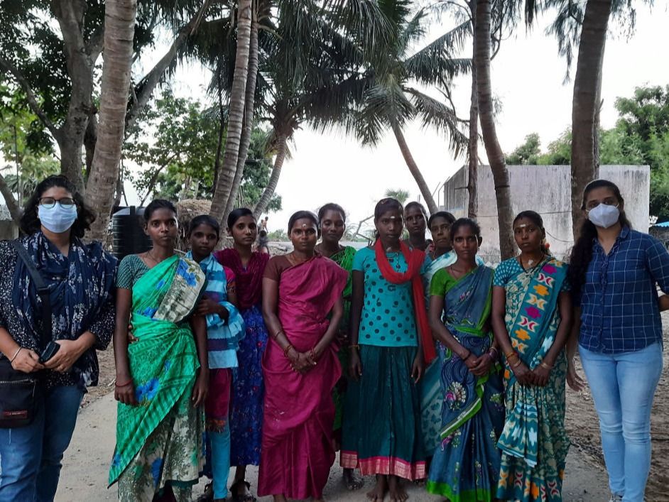 All-women Workforce of Inara Project, flanked by two masked female students on either side