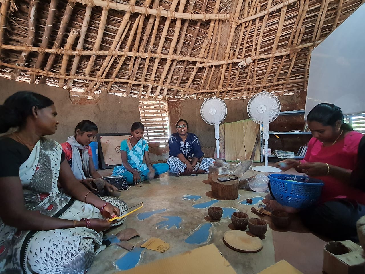 Workers making handicrafts in a small wooden hut